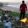 A displaced man fleeing airstrikes in Dahiyeh sets a fire to warm his family on the Beirut corniche.
