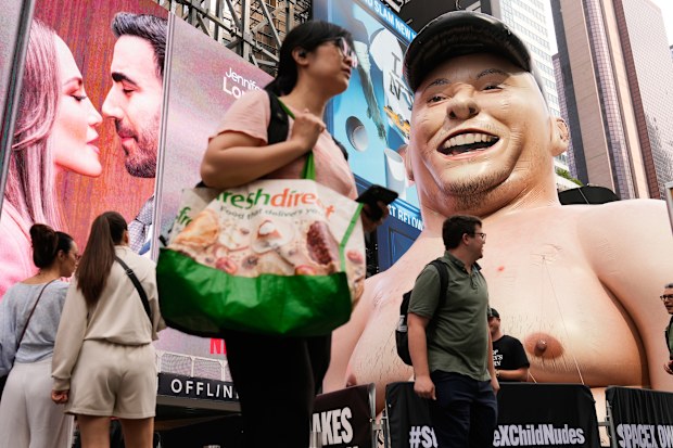 A large inflatable figure depicting Elon Musk stands in Times Square in New York.