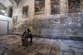 A member of the restoration team removes a stone from the floor of the Church of the Holy Sepulchre.
