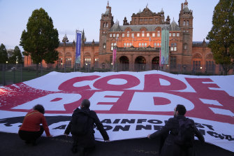 Climate activists unfurl a large “Code Red” banner outside the climate talks in Glasgow.
