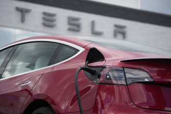 A 2021 Model 3 sedan charges at a Tesla dealership.