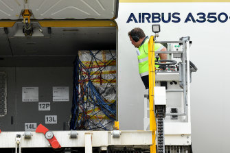 The first shipment of Pfizer COVID-19 vaccines is unloaded from a Singapore Airlines plane at Sydney International Airport on Monday. 