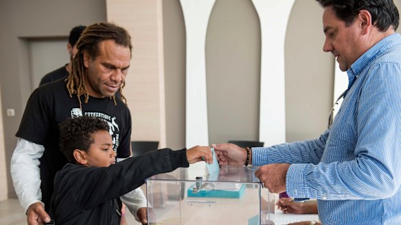 A boy helps his father to vote in New Caledonia's second independence referendum. 