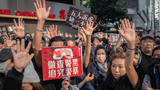 Demonstrators raise their hands on Hennessy Road in the Causeway Bay district of Hong Kong.
