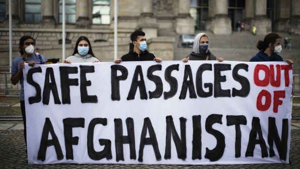 People hold a poster demanding a safe passage out of Afghanistan, during a demonstration in Berlin, Germany.