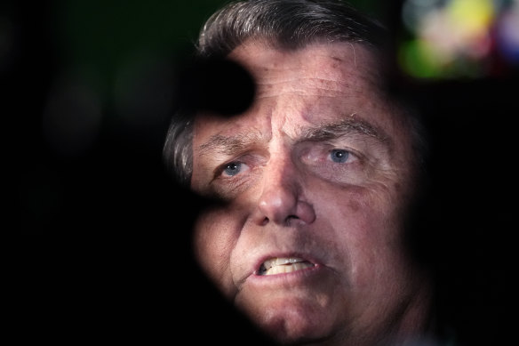 Former Brazilian president Jair Bolsonaro speaks to media after arriving at the airport in Brasilia.