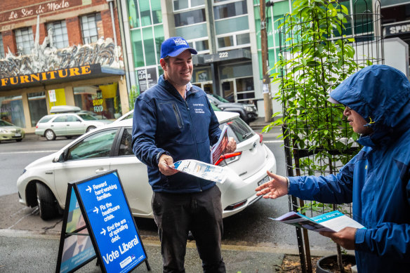 Liberal Party candidate for Richmond Lucas Moon hands out how-to- vote cards at an early voting centre.