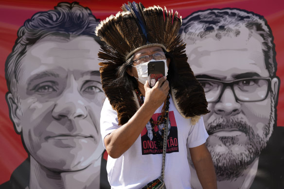 Indigenous leader Kamuu Wapichana speaks in front of a banner showing freelance British journalist Dom Phillips, left, and Indigenous expert Bruno Pereira.