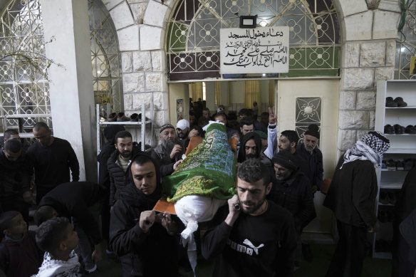 Yas tutanlar, Batı Şeria'nın El Halil kentindeki cenazesi sırasında Nassim Ebu Fuda'nın naaşını taşıyor.  Filistin Sağlık Bakanlığı, İsrail güçlerinin Pazartesi günü işgal altındaki Batı Şeria'daki parlama noktasında bir Filistinli adamı vurarak öldürdüğünü söyledi. 