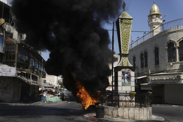 Tyres burn during an Israeli military raid in the militant stronghold of the Jenin refugee camp.