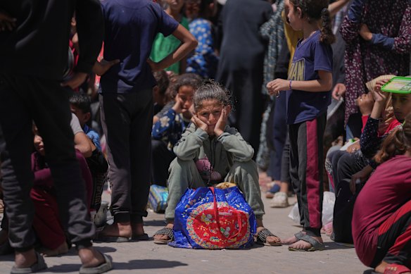 周五，一个巴勒斯坦女孩在等待从加沙地带Deir Al-Balah的一家分销厨房收集捐赠的食物。
