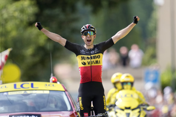 Belgium’s Wout Van Aert celebrates as he crosses the finish line to win the 11th stage.