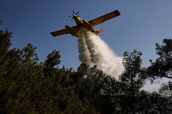 Un avion bombardant d'eau propage l'eau pour éteindre un incendie dans une zone boisée à Guzelyeli, à la périphérie de Canakkale, au nord-ouest de la Turquie.