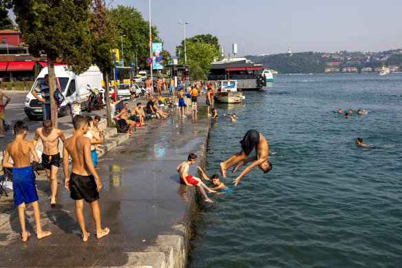 People cool off by the Bosphorus to escape hot weather in Istanbul, Turkey on July 14.