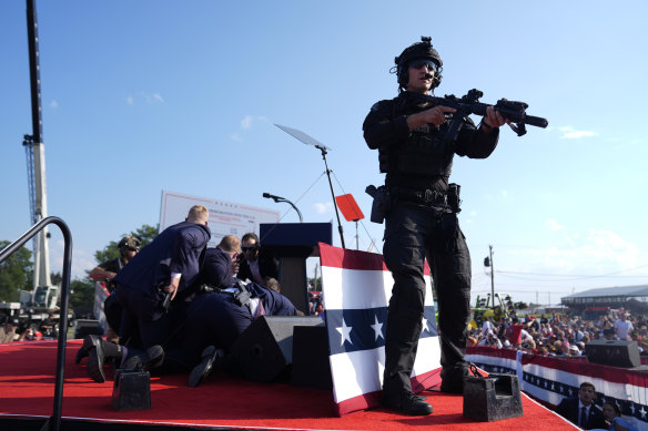 Secret Service agents cover Donald Trump on the stage in Butler, Pennsylvania.