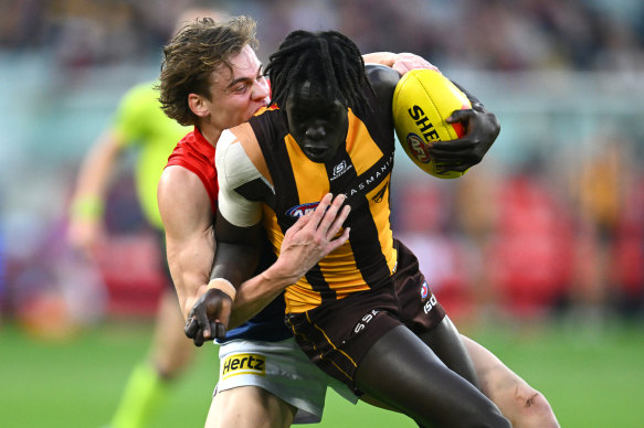 Hawthorn’s Changkuoth Jiath is caught in a tackle by Melbourne’s Trent Rivers.