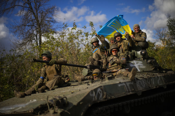 krainian soldiers sit on an armoured vehicle as they drive on a road between Izium and Lyman in Ukraine.