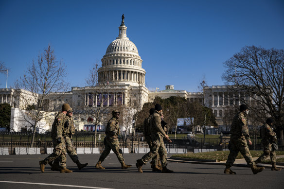 Members of the National Guard walk past a security perimeter outside the US Capitol as preparations are made ahead of the presidential inauguration in Washington.