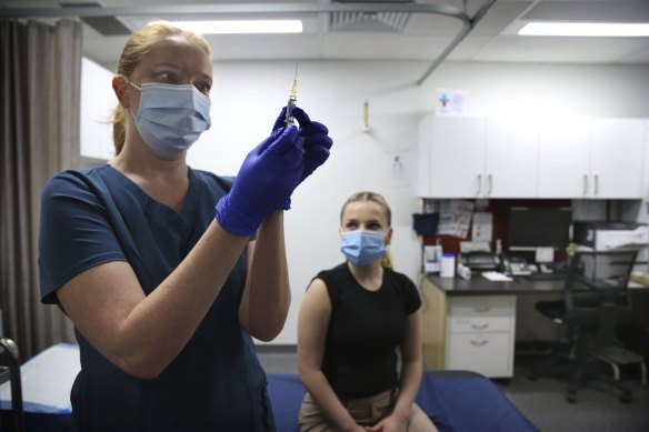 Nurse Mariia Kulchitska prepares a dose of flu vaccine for patient Bronte May-Horswood at the O’Connell Street Clinic in Sydney on Wednesday.