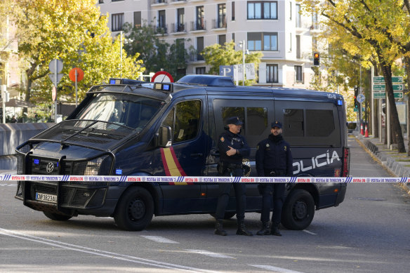 Police officers stand guard as they cordon off the area next to the US embassy in Madrid, Spain.