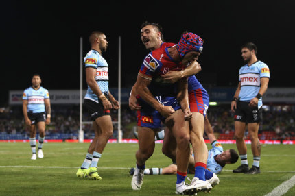 Knights star Kalyn Ponga (headgear) celebrates a try on Friday night.