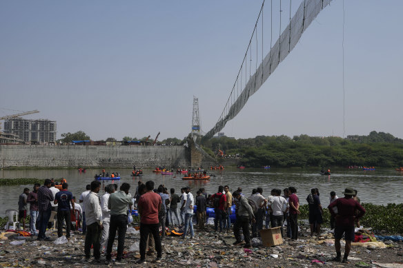 Rescuers on boats search in the Machchu river next to the pedestrian bridge that collapsed in the state of Gujarat, India.