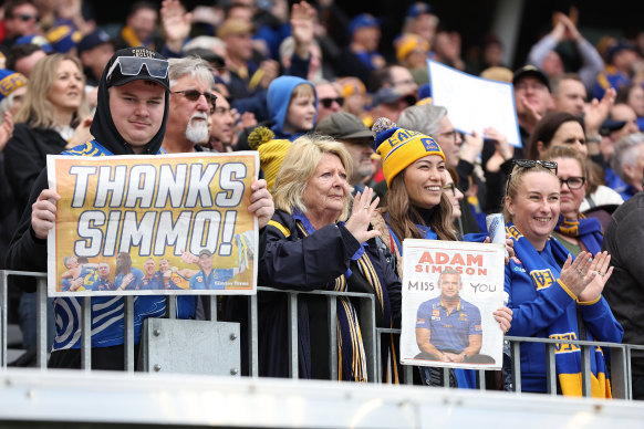Spectators show their appreciation for Adam Simpson.