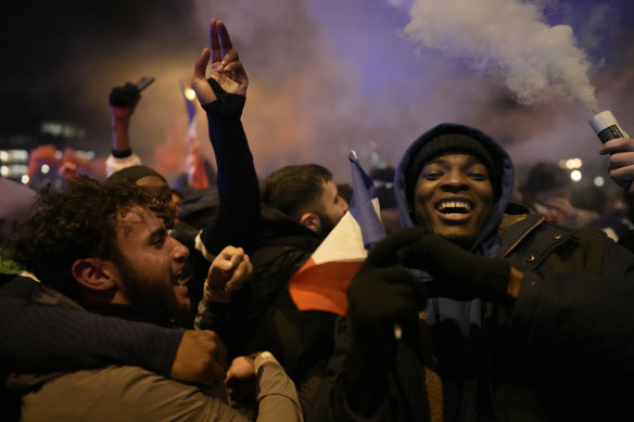 Supporters of France react next to the Arc de Triomphe on the Champs Elysees in Paris at the end of the FIFA World Cup semifinal between France and Morocco.