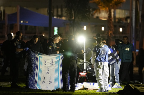 Israeli police stand by the body of a man they shot after he rammed a car into a group of people near a popular seaside park in Tel Aviv, Israel.