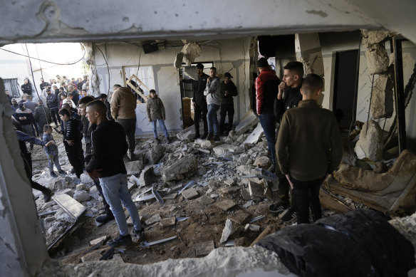 Palestinians look at the aftermath of an Israeli military raid on Jenin refugee camp in the West Bank.