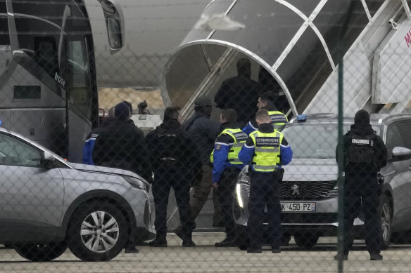 Men board the plane grounded by police at the Vatry airport.