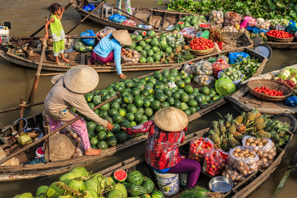 Vietnamese women selling and buying fruits on floating market, Mekong River Delta.