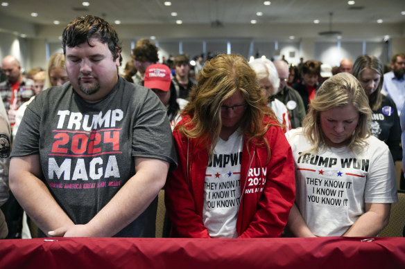 Supporters pray before former president Donald Trump speaks in Sioux Centre, Iowa on Friday.
