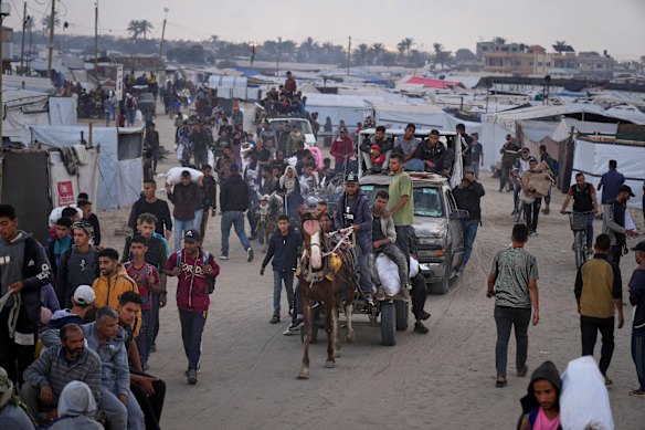 Palestinians carry bags filled with food and humanitarian aid provided by the Gaza Humanitarian Foundation in Khan Younis.