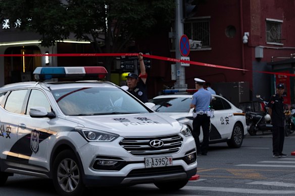Police close off the road leading to CITIC Tower in Beijing after an aircraft crashed into it.