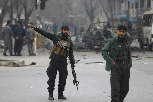 Afghan security personnel inspect the site of a bomb attack in Kabul on Boxing Day.