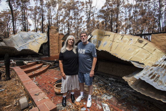 Liz and Nigel Girvan in the ruins of their Mallacoota home. There is no time frame to start the rebuild.