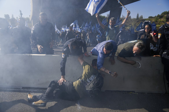 Israeli police officers disperse demonstrators blocking a highway leading to Jerusalem.