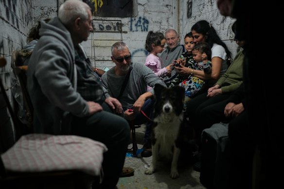 People sit in a bomb shelter as air raid sirens warn of incoming Iranian missile strikes in Holon, Israel.