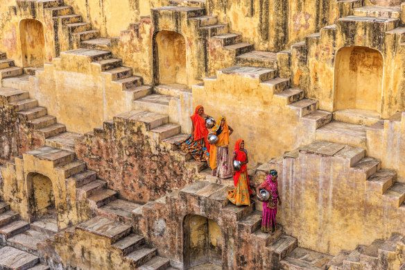 Women carry water from stepwell in Rajasthan, India.