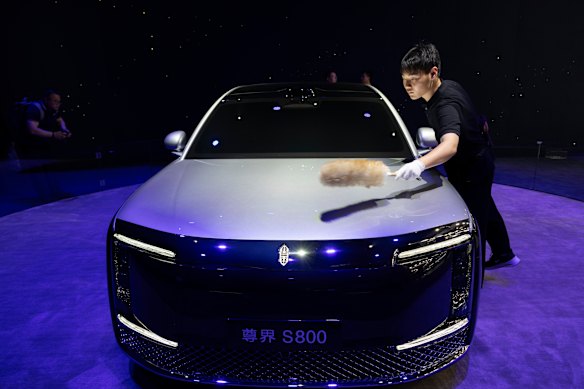 A worker brushes off the dust on a Huawei Maextro S800, China’s answer to Maybach.