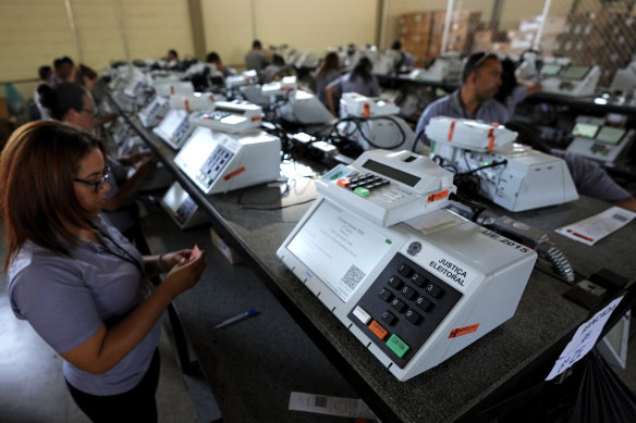 Electoral Court employees in Brasilia work on the final stage of sealing electronic voting machines in preparation for the presidential run-off on October 30.