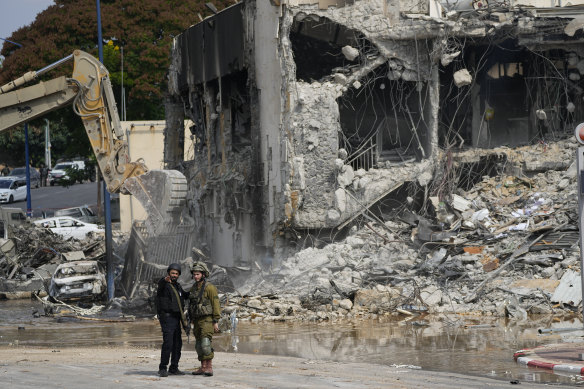 A digger removes the rubble from the Sderot police station on Sunday, which Hamas fighters overran.