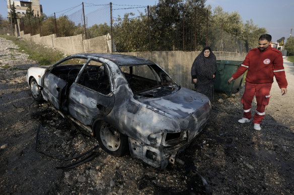 Filistinliler, Batı Şeria'nın Nablus kenti yakınlarındaki Burin köyünde sakinlerinin İsrailli yerleşimciler tarafından ateşe verildiğini söylediği yanmış bir arabayı inceliyor.