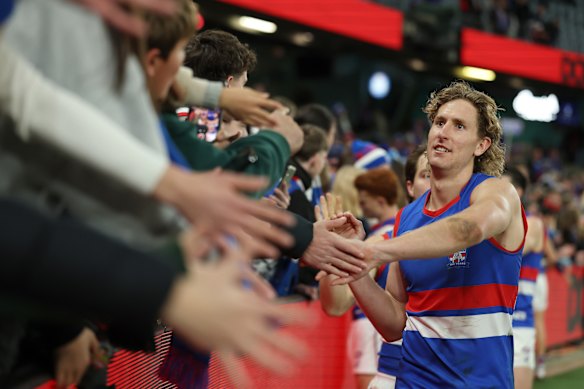 Aaron Naughton celebrates with Bulldogs fans after the game.