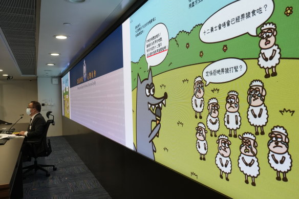 A senior police superintendent speaks in front of a screen showing the contents of children’s books.