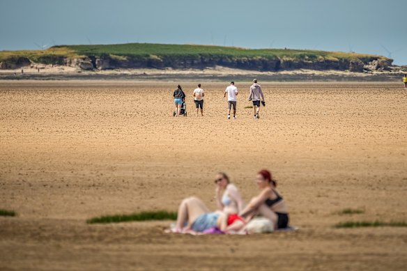 月曜日、英国ウェスト・カービーのビーチにいる人々。