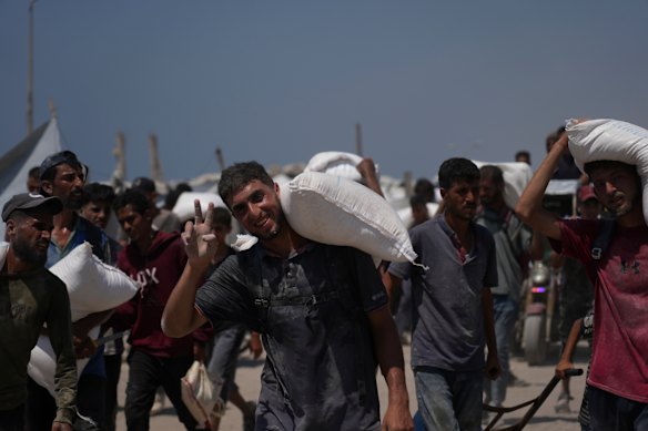 Os palestinos carregam sacos de exposições de farinha de ajuda humanitária ao Conloy que chegou à cidade de Gaza nos últimos dias.