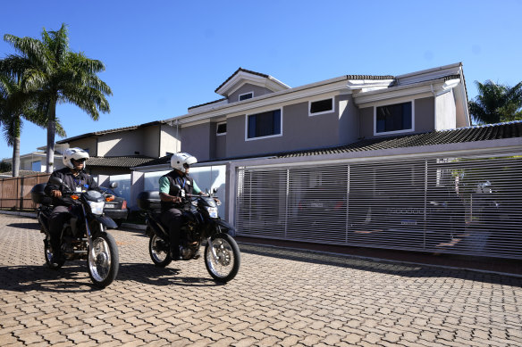 Security guards pass in front of the home of former Brazilian president Jair Bolsonaro in Brasilia.