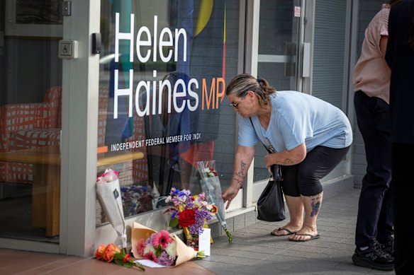 A woman laying flowers outside Helen Haines’ electorate office in Wangaratta.